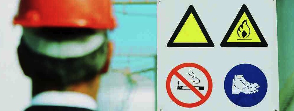 Man looking at health and safety sign in hard hat 